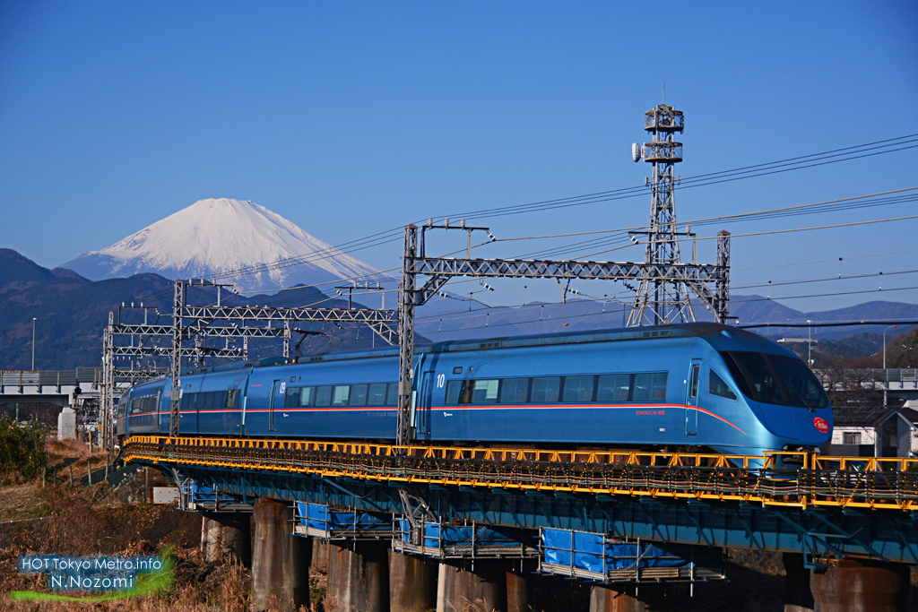 澄んだ青空と雪化粧した富士山をバックにロマンスカーを撮影