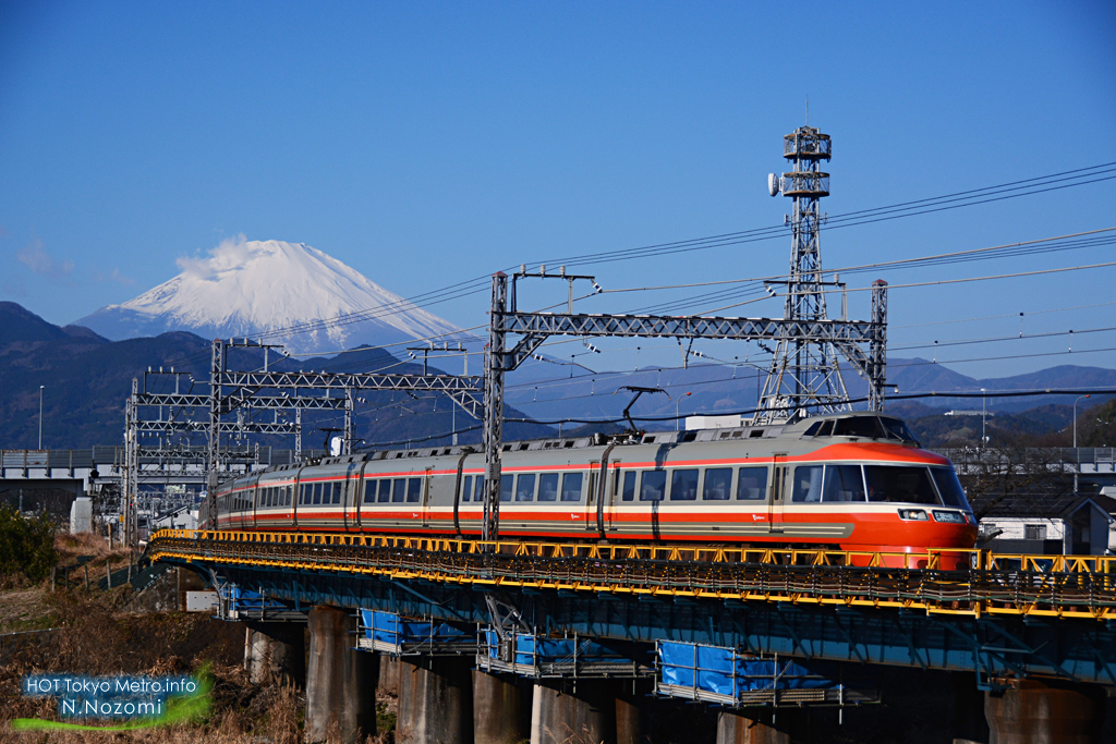 澄んだ青空と雪化粧した富士山をバックにロマンスカーを撮影