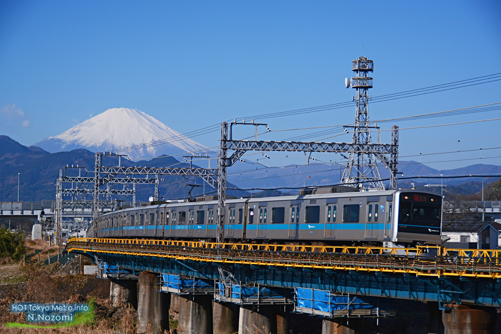 澄んだ青空と雪化粧した富士山をバックにロマンスカーを撮影