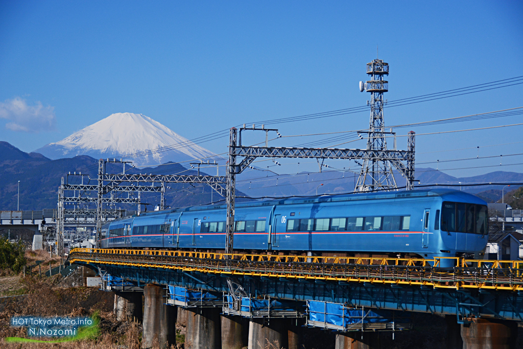 澄んだ青空と雪化粧した富士山をバックにロマンスカーを撮影