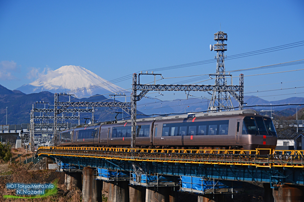 澄んだ青空と雪化粧した富士山をバックにロマンスカーを撮影