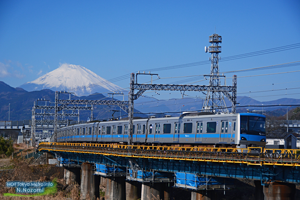 澄んだ青空と雪化粧した富士山をバックにロマンスカーを撮影