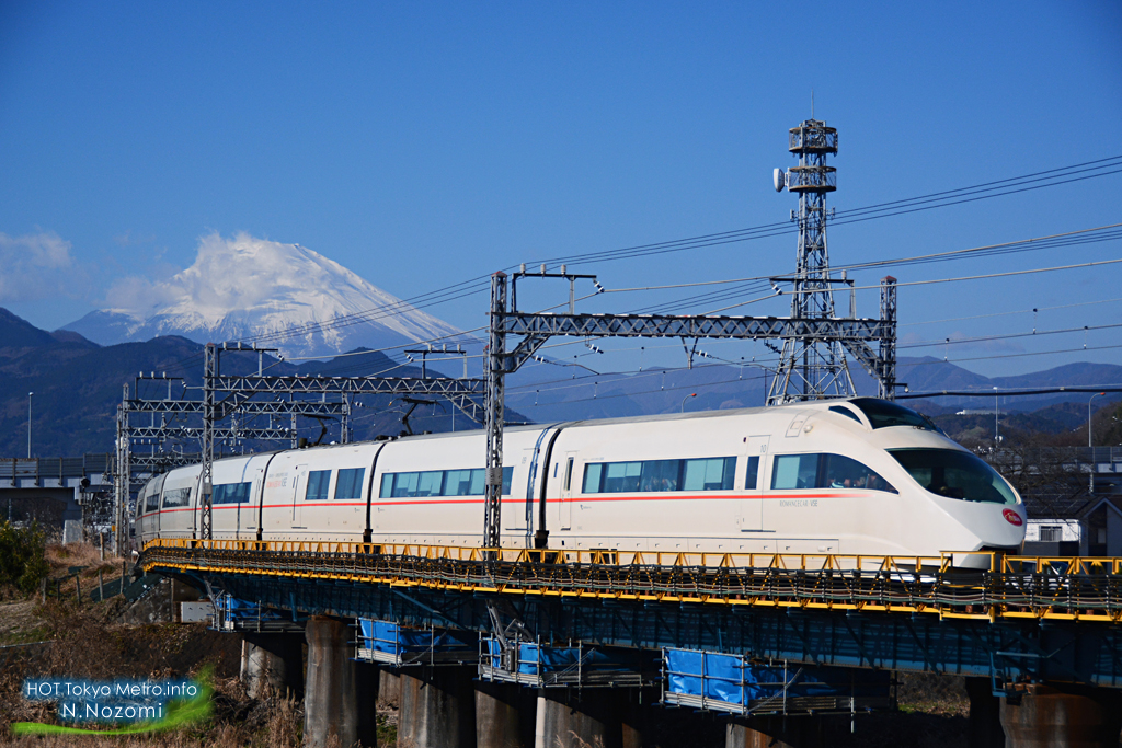 澄んだ青空と雪化粧した富士山をバックにロマンスカーを撮影